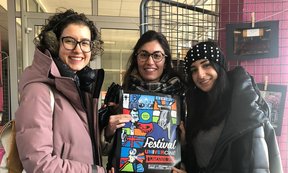 Drei Studentinnen stehen für ein Gruppenfoto zusammen.